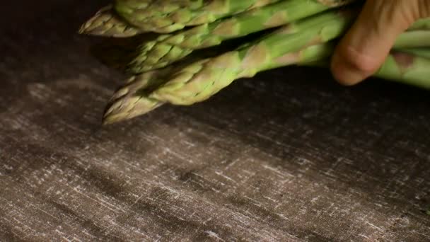 Bunch of fresh green asparagus on dark wooden table, healthy eating, seasonal products — Stock Video