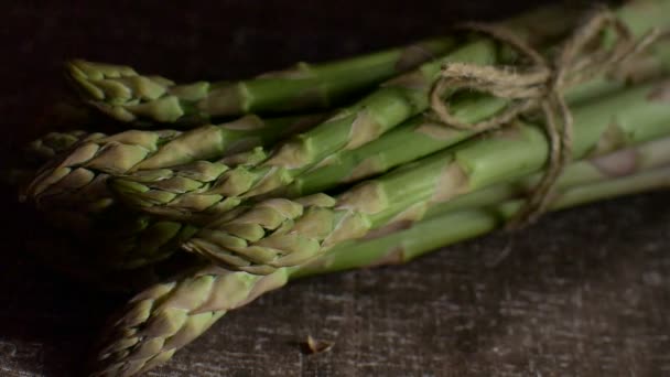 Bündel frischen grünen Spargels auf dunklem Holztisch, gesunde Ernährung, saisonale Produkte — Stockvideo