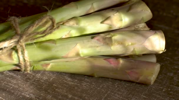 Bouquet d'asperges vertes fraîches sur table en bois foncé, alimentation saine, produits de saison — Video