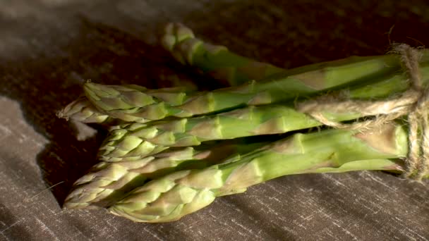 Stelletje verse groene asperges op donkere houten tafel, gezond eten, seizoensproducten — Stockvideo