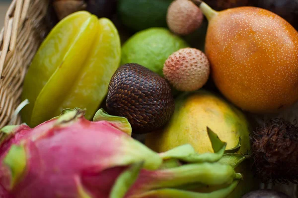 Großer Korb mit frischen tropischen Früchten, Passionsfrüchten, Karambolen, Drachenfrüchten oder Pitaya, Mangostan, Lichi, Granadilla. Exotische Früchte, gesundes Essen — Stockfoto