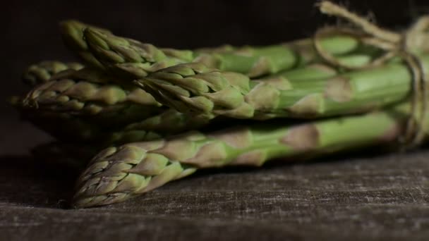 Група свіжих зелених спаржі на темному дерев'яному столі, здорове харчування, сезонні продукти — стокове відео