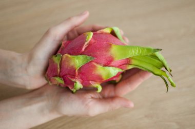 Olgunlaşmış taze organik ejderha meyvesi ya da pitaya, pitahaya tutan kadın eller. Egzotik meyveler, sağlıklı beslenme konsepti