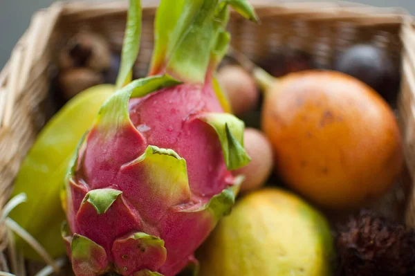 Großer Korb mit frischen tropischen Früchten, Passionsfrüchten, Karambolen, Drachenfrüchten oder Pitaya, Mangostan, Lichi, Granadilla. Exotische Früchte, gesundes Essen — Stockfoto