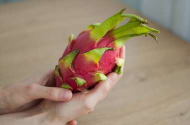 Olgunlaşmış taze organik ejderha meyvesi ya da pitaya, pitahaya tutan kadın eller. Egzotik meyveler, sağlıklı beslenme konsepti
