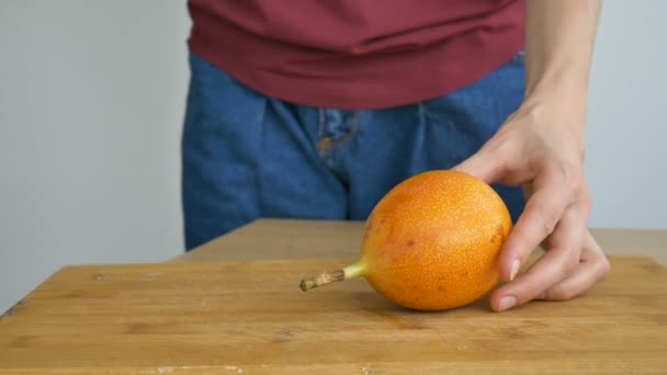 싱싱 하게 익은 그라나다 야 혹은 노란색의 정열 과일을 나무판에서 반으로 자른다. 특이 한 과일, 건강에 좋은 식사 개념 — 비디오