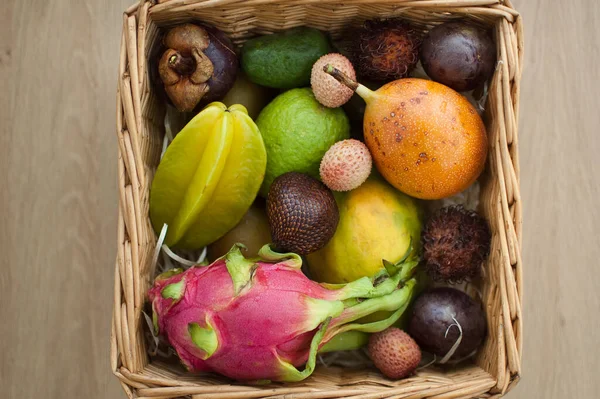 Großer Korb mit frischen tropischen Früchten, Passionsfrüchten, Karambolen, Drachenfrüchten oder Pitaya, Mangostan, Lichi, Granadilla. Exotische Früchte, gesundes Essen — Stockfoto