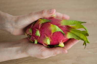 Olgunlaşmış taze organik ejderha meyvesi ya da pitaya, pitahaya tutan kadın eller. Egzotik meyveler, sağlıklı beslenme konsepti