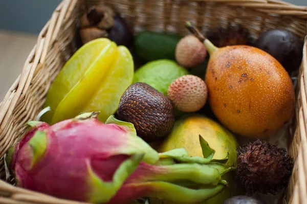 Großer Korb mit frischen tropischen Früchten, Passionsfrüchten, Karambolen, Drachenfrüchten oder Pitaya, Mangostan, Lichi, Granadilla. Exotische Früchte, gesundes Essen — Stockfoto