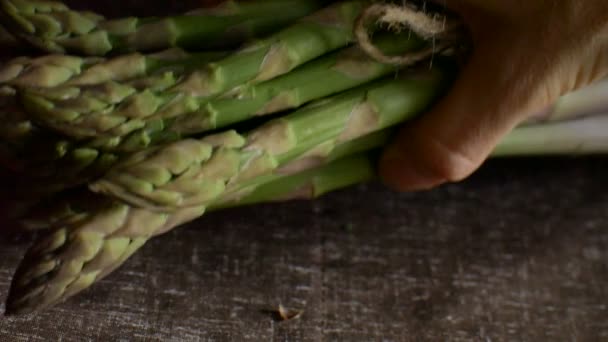 Bündel frischen grünen Spargels auf dunklem Holztisch, gesunde Ernährung, saisonale Produkte — Stockvideo