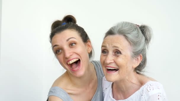 Feliz madre mayor está abrazando a su hija adulta, las mujeres se ríen juntas, familia sincera de diferentes generaciones de edad que se divierten en el fondo blanco — Vídeos de Stock