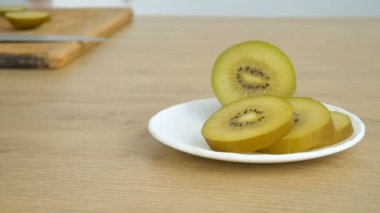 Kadın eli, sarı hamurlu bir dilim altın kivi bırakır. Sağlıklı yiyecek, taze organik elma meyvesi.