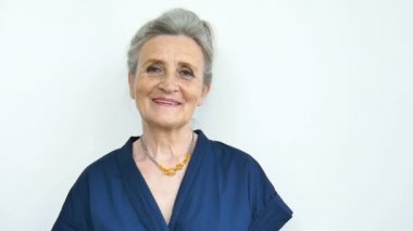 Gri saçlı ve buruşuk suratlı güzel yaşlı büyükanne kameraya bakıyor beyaz arka planda gülümseme ile, anneler günü, mutlu emeklilik