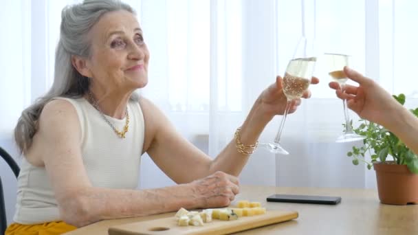 Portrait féminin de la mère aînée parlant et buvant de l'alcool et des lunettes à la maison assise à la table, retraite heureuse, concepts de la fête des mères, dépendance à l'alcool — Video