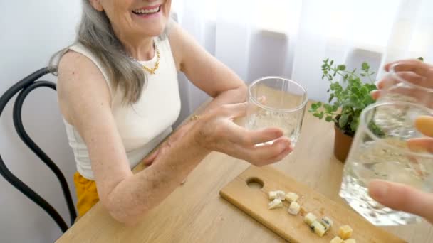 Portrait féminin de la mère aînée parlant et buvant de l'alcool et des lunettes à la maison assise à la table, retraite heureuse, concepts de la fête des mères, dépendance à l'alcool — Video