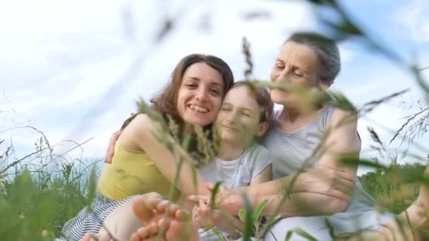 Schattig kind meisje met haar jonge moeder en senior oma hebben picknick tijdens de zomer buiten in de natuur, moeders dag, gelukkig pensioen, multi generatie familie — Stockvideo