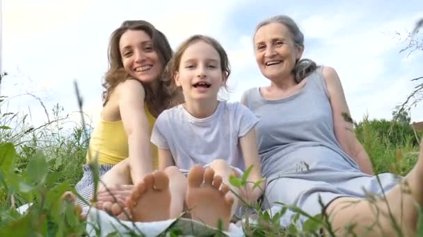 Nettes Kindermädchen mit ihrer jungen Mutter und Großmutter picknicken im Sommer draußen in der Natur, Muttertag, glücklicher Ruhestand, Mehrgenerationenfamilie — Stockvideo