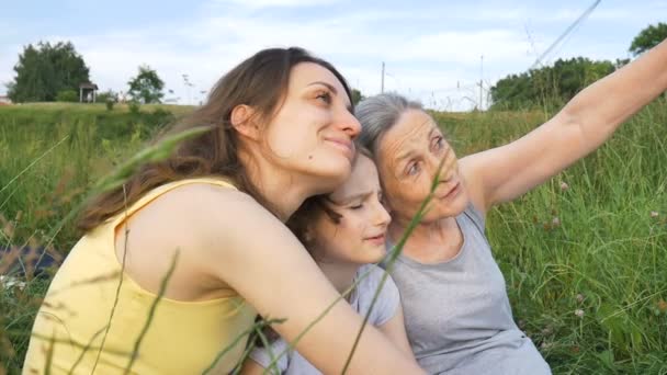 可爱的小女孩和她的年轻妈妈及老奶奶正在野外野餐，母亲节快乐，退休快乐，多代同堂 — 图库视频影像