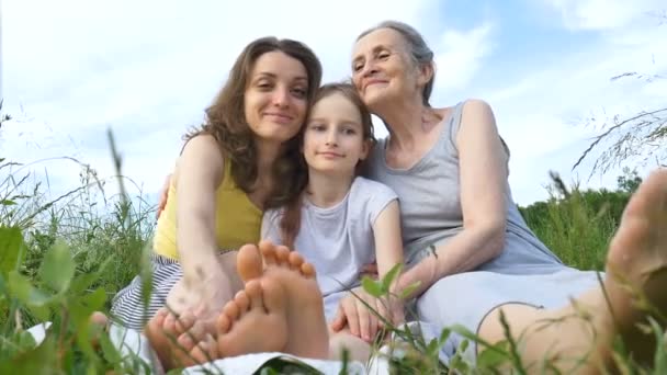 Мила дівчинка з молодою матір'ю і старшою бабусею проводить пікнік під час літа на природі, день матерів, щасливий вихід на пенсію, сім'я багато поколінь — стокове відео