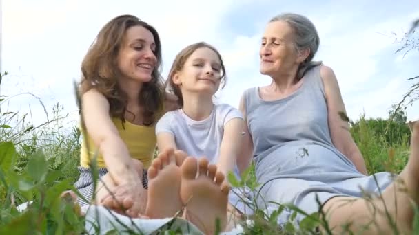 어린 어머니와 할머니와 함께 귀여운 딸 과 함께 여름 야외에서 소풍을 즐기고 있다. 어머니 날, 행복 한 은퇴, 다 세대 가족 — 비디오