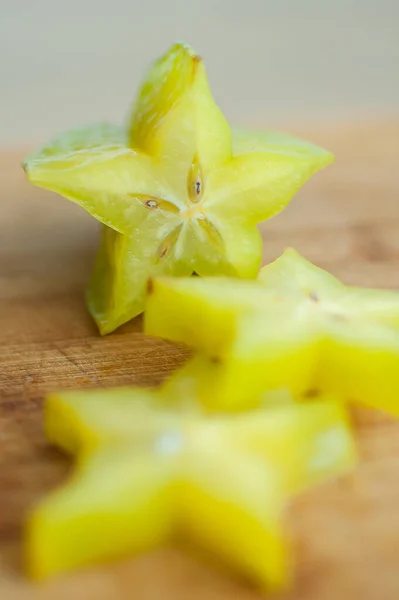 Exotické hvězdné ovoce nebo averrhoa karamboly na dřevěné řezné desce. Zdravé jídlo, čerstvé organické hvězdné jablečné ovoce. — Stock fotografie