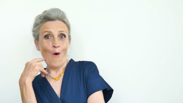 Vacker gammal rolig mormor med grått hår och ansikte med rynkor grimaserar medan du tittar på kameran på vit bakgrund, mödrar dag, glad pensionering — Stockvideo