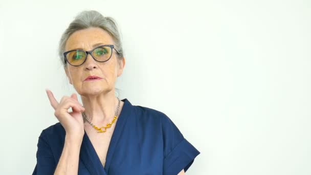 Kvinnligt porträtt av allvarlig mormor med grått hår och ansikte med rynkor bär glasögon på vit bakgrund, mödrar dag, glad pensionering — Stockvideo