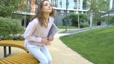 Dizüstü bilgisayarın klavyesinde yazan genç bir kadın, modern binanın arka planında dijital tablet kullanan bir iş kadını, açık havada çalışan bir hesap yöneticisi, uzak bir iş.