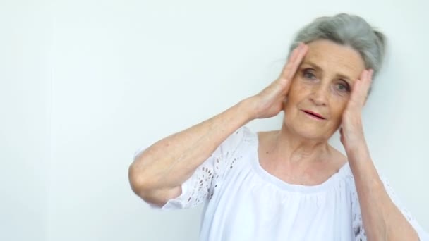 Close-up portret van overstuur senior volwassen vrouw spijt over iets en het houden van twee handen in de buurt van haar hoofd. Negatieve emotie, gezichtsuitdrukking, gevoel — Stockvideo