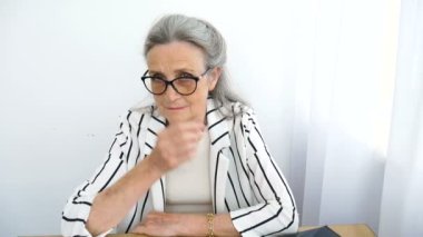 Kızgın, yaşlı, olgun bir iş kadınının ofisten biriyle konuşmasının yakın plan portresi. Olumsuz duygu, yüz ifadesi, skandal.