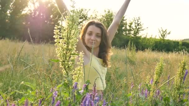 Красивая молодая девушка сидит посреди поля с цветами в летнее время, повышенной чувствительностью, астмой или аллергией — стоковое видео