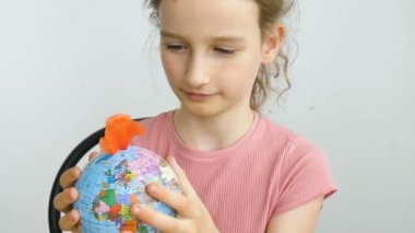 Ukrayna Kiril alfabesiyle yazılmış ve içinde çiçekler büyüyen coğrafi isimlere sahip dünya küresi küçük sarışın bir kız tarafından tutuluyor. İnsan sorumluluğu, dünya ellerde, çevre dostu kavramlar