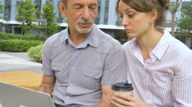 Yaşlı iş arkadaşı genç bayana ders veriyor, çalışanlara geri bildirim, koordinasyon, eğitim ortaklığı kavramları veriyor..