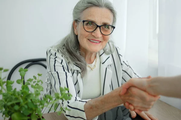 La mujer de negocios madura está liderando una entrevista con un nuevo colega y estrechando la mano al final. Concepto gente de negocios —  Fotos de Stock