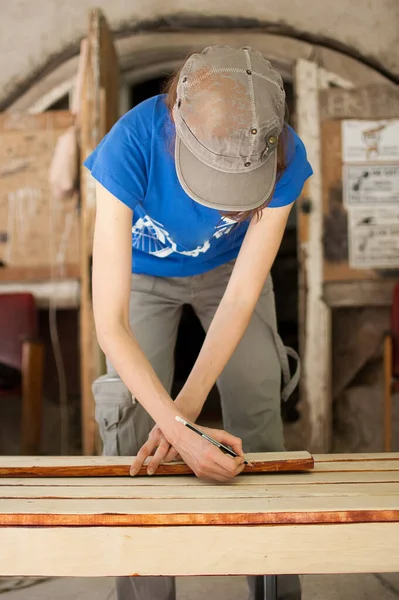 Le mani femminili stanno facendo alcuni segni su tavola di legno per i buchi futuri usando la matita per assemblare panca, uguaglianza di genere, femminismo, fai da te concetti. — Foto Stock