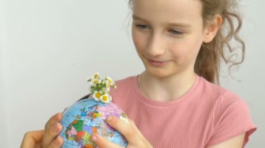Ukrayna Kiril alfabesiyle yazılmış ve içinde çiçekler büyüyen coğrafi isimlere sahip dünya küresi küçük sarışın bir kız tarafından tutuluyor. İnsan sorumluluğu, dünya ellerde, çevre dostu kavramlar