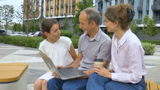 Senior businessman mentor nebo kouč učí stážisty, ukazuje na obrazovku notebooku, pomáhá novým zaměstnancům s firemním softwarem, dává instrukce, kolegové spolupracují — Stock video