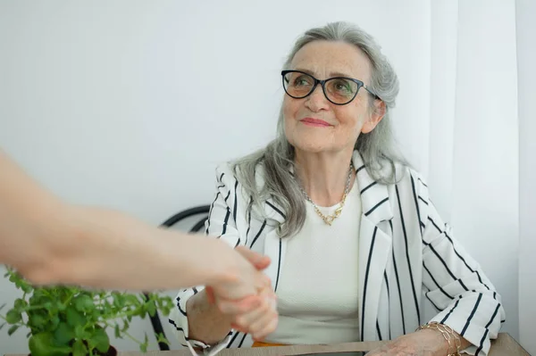 Olgun bir iş kadını yeni bir meslektaşıyla röportaj yapıyor ve sonunda el sıkışıyor. İş adamları konsepti — Stok fotoğraf