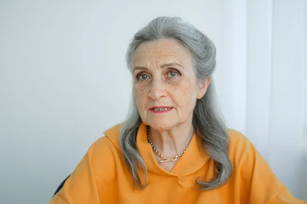 Portret pięknej babci z siwymi włosami i twarzą ze zmarszczkami patrzącej w kamerę, Dzień Matki, Szczęśliwej emerytury — Zdjęcie stockowe