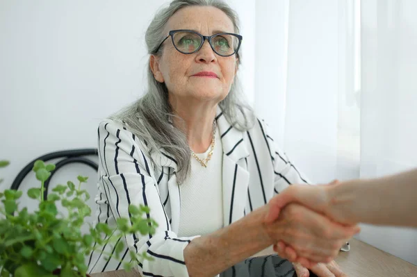 La mujer de negocios madura está liderando una entrevista con un nuevo colega y estrechando la mano al final. Concepto gente de negocios —  Fotos de Stock