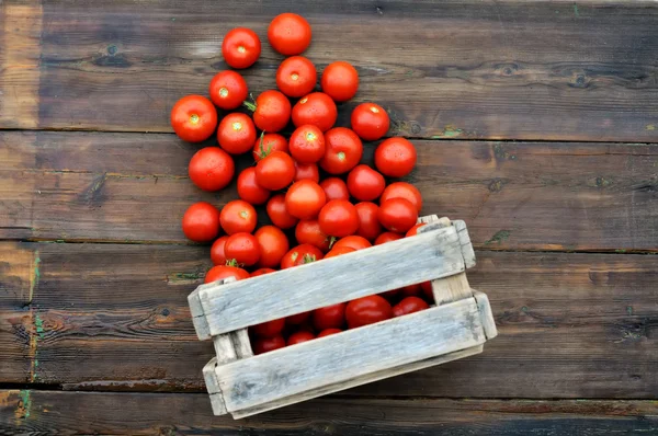 Διάσπαρτα ντομάτες σε ένα ξύλινο κουτί — Φωτογραφία Αρχείου