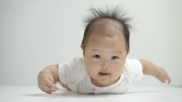 Asiatische chinesische Baby auf seinem Bauch auf weißen isolierten Hintergrund — Stockvideo
