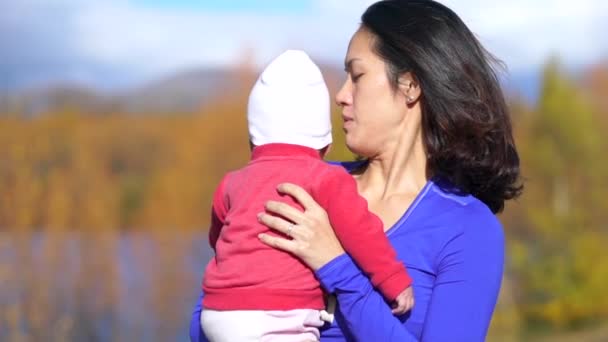 Asiatisk kinesisk mor tröstar hennes baby utomhus — Stockvideo