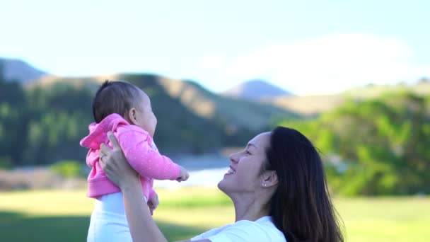 Asiática jovem mãe levantando seu bebê e brincando — Vídeo de Stock