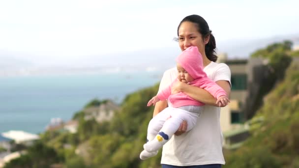 Asian chinese young mother carrying her new born outdoors in the mountains — Stock Video