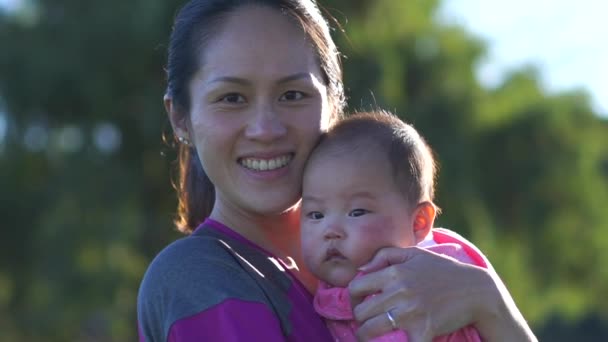 Медленное движение крупным планом матери и ребенка в подсветке парка — стоковое видео