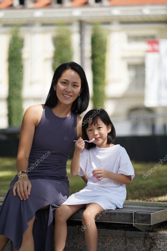 asian chinese child enjoying the moment with mother after tasting ice cream