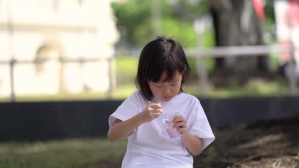 Nahaufnahme Asiatisches Chinesisches Mädchen Isst Zum Ersten Mal Hungrig Eis — Stockvideo