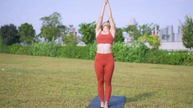 Dışarıda Asyalı kadın yogası gündoğumunun yörüngesinde.