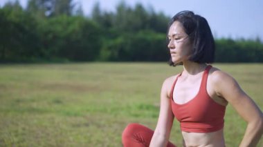 Bekar Asyalı Çinli kadın yogi yogası sabah yeşil bahçe çayırında